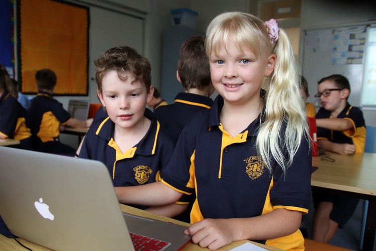 2 Stage 2 students workign together at a laptop in the classroom