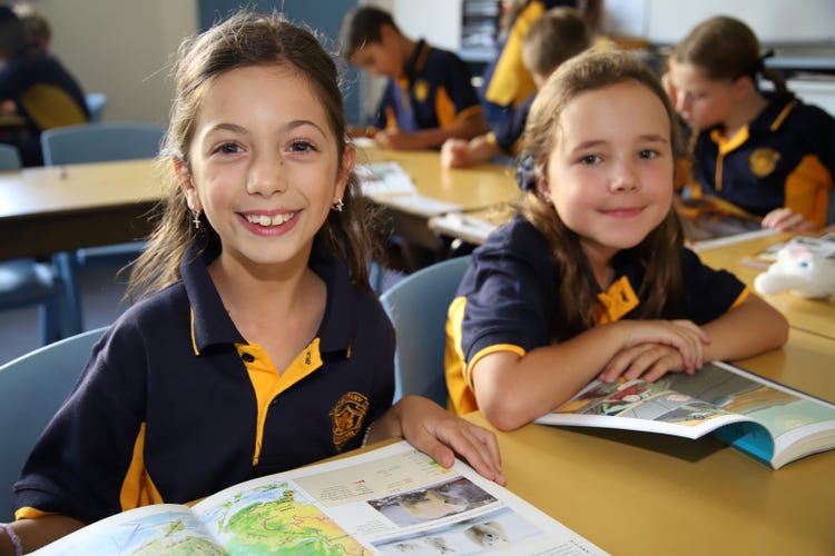 2 Stage 2 students reading books in a classroom